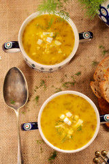 Sorrel soup in a vintage bowl with egg and bread on a wooden table