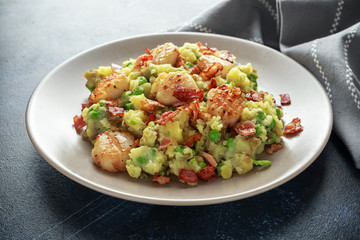 Fried scallops with mash potato, green peas and bacon