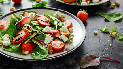 Summer Fruit Strawberry, spinach Salad with walnut, feta cheese balsamic vinegar, kale. in a plate. concepts health food