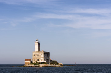 Fototapeta na wymiar Lighthouse of Bocca island at Lido del Sole beach in Olbia harbor, Sardinia, Italy