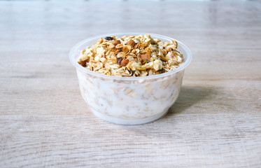 close up  muesli in bowl with milk or yogurt on wooden background, granola healthy meal, food organic concept