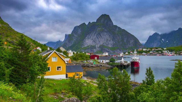4k timelaspe Moving clouds over traditional Norwegian fisherman's cabins, rorbuer, on the island of Hamnoy, Reine, Lofoten islands, Summer of Norway.