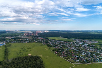 Fototapeta na wymiar Aerial view of wheat fields, meadow, forest and village in rural Russia.