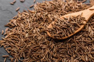 Seeds of cumin on a dark stone background