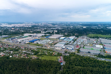 Fototapeta na wymiar Aerial view of wheat fields, meadow, forest andindustrial warehouses in rural Russia.