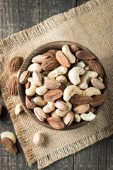 Healthy mix nuts on wooden background. Almonds, hazelnuts, cashews, peanuts, pistachios, brazilian nuts