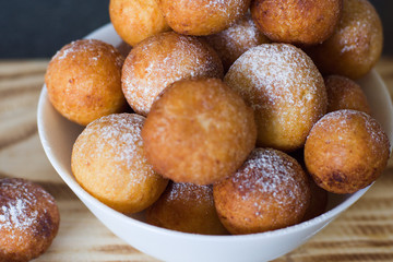 Donuts from cottage cheese, delicious dessert. Close-up. Soft focus. Donuts in Italian on a wooden board