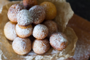 Donuts close-up. Italian fritters - traditional dish on a gray background on a wooden board.