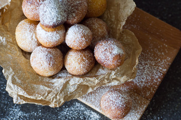 Donuts close-up. Italian fritters - traditional dish on a gray background on a wooden board.