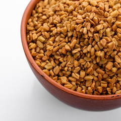 fragrant grains of fenugreek on a white background