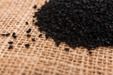 grains of black cumin and oil on the rustic background