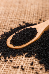 grains of black cumin and oil on the rustic background