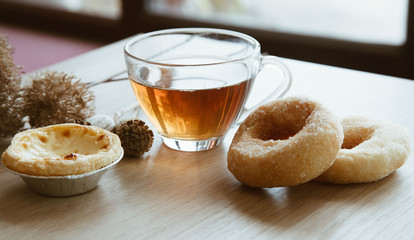 tea time and egg tart and donut on wooden table