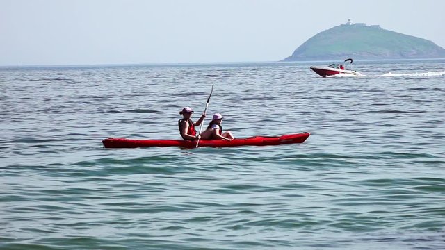 A woman rows a kayak in the ocean