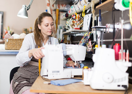 Woman is working with sewing machine for new fashion collection
