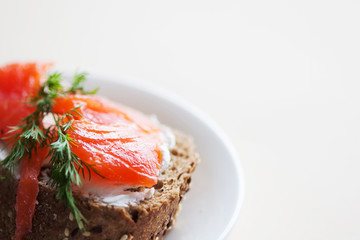 Sandwich with salmon and cream cheese. On a piece of rye multi-grain bread.