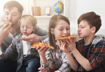 Portrait of happy family eating pizza at home