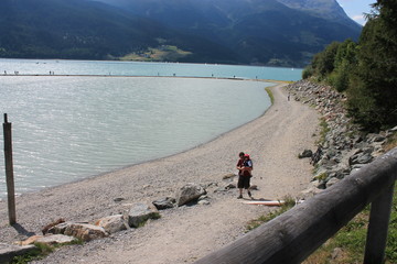 Fototapeta na wymiar padre e figlio sulle rive del lago di resia in alto adige durante le vacvanze estive