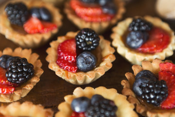 Berry tartlets dessert on wooden background