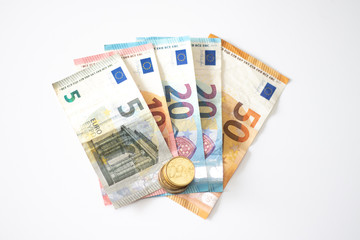 Euro banknoted and a stack of euro coins isolated on white background