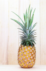 Ripe pineapple on  wood background.