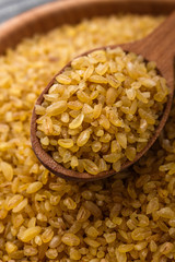 raw bulgur on a rustic wooden background