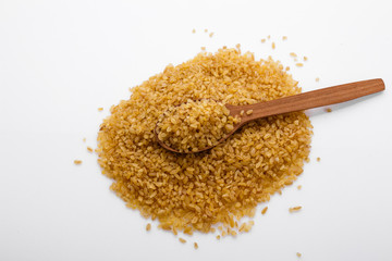 raw bulgur on a white acrylic background