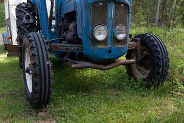 tires on a blue tractor standing i gras
