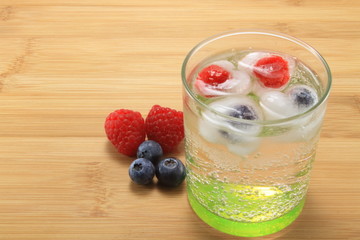 cocktail acqua tonica con ghiaccioli di lampone e mirtilli, frasca, dissetante