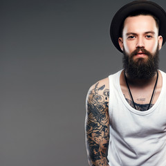 Bearded Man in Hat. hipster boy with tattoo