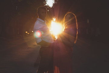 Silhouette of a pregnant young couple at sunset