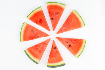 Fresh sliced red watermelon with seeds forming a circle pattern isolated.