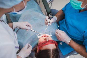 doctor orthodontist performs a procedure for cleaning teeth