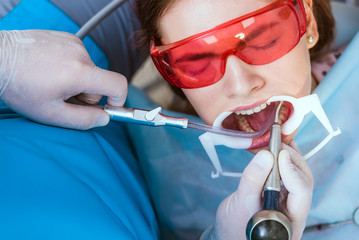 doctor orthodontist performs a procedure for cleaning teeth