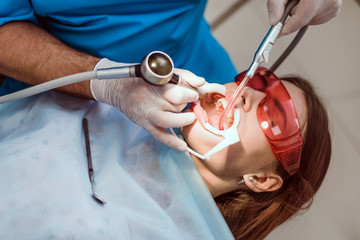 doctor orthodontist performs a procedure for cleaning teeth