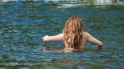 portrait of redhead girls swimming in the lake on back view