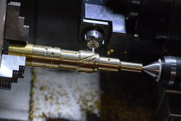 The CNC turning or lathe machine cutting groove slot at the brass shaft  by the milling spindle. Hi - technology manufacturing process.
