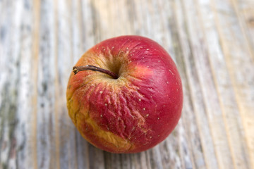 Alter, schrumpeliger Apfel auf Holztisch