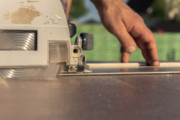 A carpenter cuts a kitchen worktop with a circular saw. He uses an attachment rail for a straight cut. Concept: construction site or craft