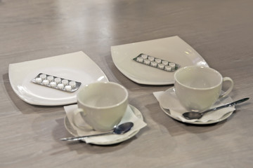 the packaging of tablets lies in the saucer on the table