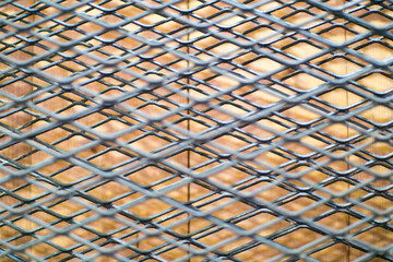 Black wire mesh, which is stretched over a brick wall. They make messy feeling when looking. Suitable for use as a background image.