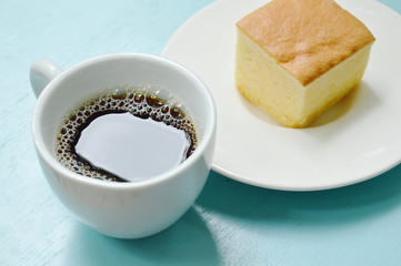 butter cake slice for piece on plate and black coffee cup