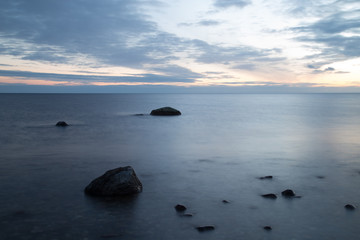 Fototapeta na wymiar Small rocks in the ocean at blue hour