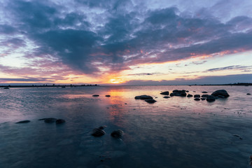 Naklejka premium Cloudy sunset by the ocean