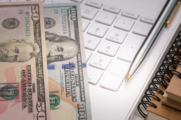 Dollar banknote with pen and keyboard for business concept