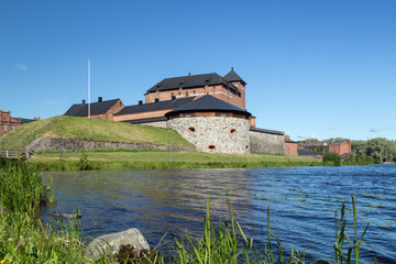 Beautiful view of the 13th century Häme Castle and lake Vanajavesi in Hämeenlinna, Finland, on a sunny day in the summer.