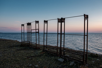 fishing equipment standing by the sea at sunset