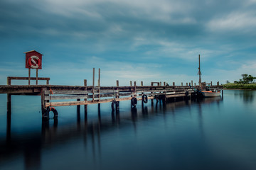 wooden jetty with life jacket and boat
