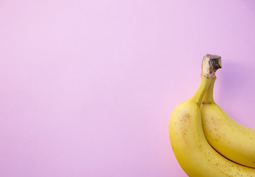 yellow banana on clear pink background. Above view