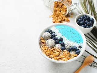 Obraz na płótnie Canvas Blue smothie in bowl with granola and berries